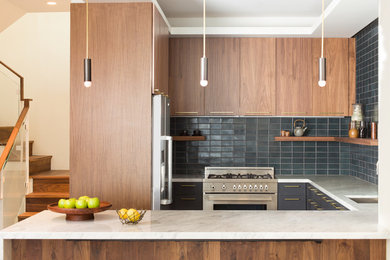 Example of a trendy u-shaped kitchen design in San Francisco with an undermount sink, flat-panel cabinets, dark wood cabinets, gray backsplash, subway tile backsplash, stainless steel appliances and a peninsula