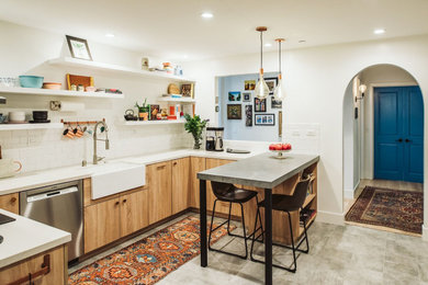 Example of a mid-sized eclectic porcelain tile and gray floor eat-in kitchen design in San Francisco with a farmhouse sink, flat-panel cabinets, light wood cabinets, quartz countertops, white backsplash, subway tile backsplash and white countertops