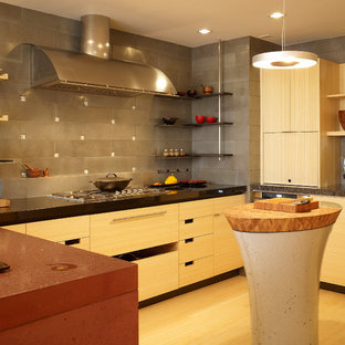 Photo of a mid-sized contemporary u-shaped eat-in kitchen in San Francisco with an undermount sink, flat-panel cabinets, light wood cabinets, concrete benchtops, grey splashback, ceramic splashback, stainless steel appliances and bamboo floors.