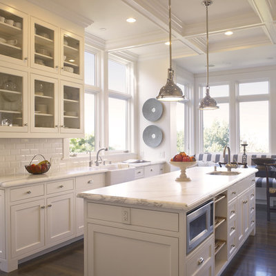 Example of a classic eat-in kitchen design in San Francisco with subway tile backsplash, a farmhouse sink, glass-front cabinets, white cabinets, white backsplash and marble countertops