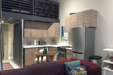 サンフランシスコにある小さなコンテンポラリースタイルのおしゃれなL型キッチン (フラットパネル扉のキャビネット、クオーツストーンカウンター、シルバーの調理設備) の写真