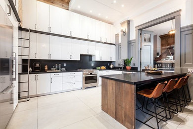 Inspiration for a large modern l-shaped kitchen/diner in San Francisco with white cabinets, stainless steel appliances, black splashback, no island, a submerged sink, flat-panel cabinets, composite countertops, stone slab splashback, porcelain flooring and beige floors.