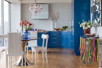 Foto på ett litet funkis kök, med en undermonterad diskho, släta luckor, blå skåp, bänkskiva i kvarts, vitt stänkskydd, stänkskydd i keramik, integrerade vitvaror, mellanmörkt trägolv och en köksö