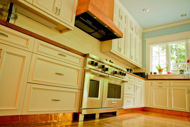 Foto de cocina clásica con armarios estilo shaker, puertas de armario blancas, encimera de madera, salpicadero amarillo, salpicadero de azulejos de cerámica y suelo de madera en tonos medios