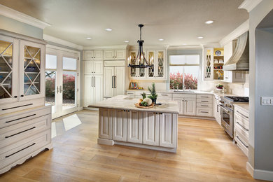 Open concept kitchen - mid-sized traditional l-shaped light wood floor open concept kitchen idea in Sacramento with an undermount sink, raised-panel cabinets, white cabinets, quartzite countertops, white backsplash, ceramic backsplash, stainless steel appliances and an island