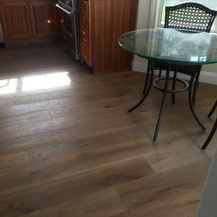 Mid-sized traditional eat-in kitchen designs - Example of a mid-sized classic l-shaped medium tone wood floor eat-in kitchen design in Orange County with an undermount sink, shaker cabinets, medium tone wood cabinets, granite countertops, brown backsplash, mosaic tile backsplash, stainless steel appliances and a peninsula