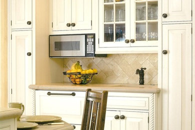 Tuscan l-shaped eat-in kitchen photo in San Luis Obispo with distressed cabinets, limestone countertops, beige backsplash, stone tile backsplash and paneled appliances