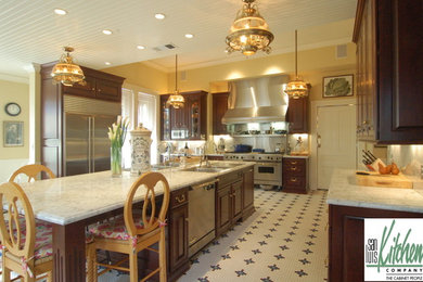 Enclosed kitchen - victorian u-shaped enclosed kitchen idea in San Luis Obispo with a drop-in sink, raised-panel cabinets, dark wood cabinets, marble countertops, white backsplash, stone slab backsplash and stainless steel appliances