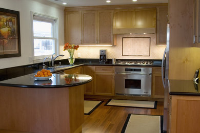 Пример оригинального дизайна: кухня в классическом стиле с техникой из нержавеющей стали, врезной мойкой, фасадами в стиле шейкер, фасадами цвета дерева среднего тона и бежевым фартуком