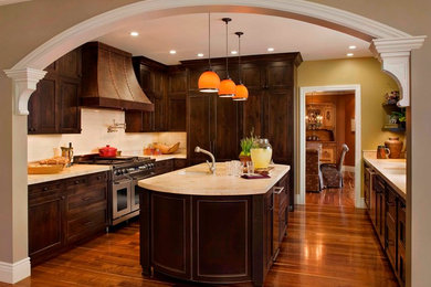 Photo of a medium sized traditional u-shaped kitchen/diner in San Francisco with an island, dark wood cabinets, white splashback, stainless steel appliances, a single-bowl sink and medium hardwood flooring.