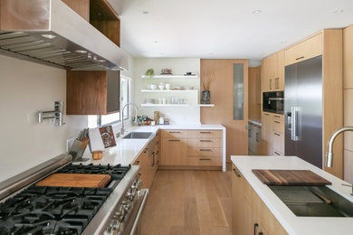 Inspiration for an asian open concept kitchen remodel in Los Angeles with flat-panel cabinets, light wood cabinets and an island