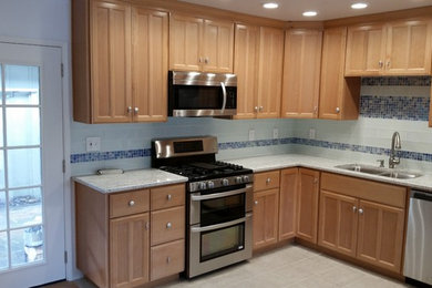 Example of a mid-sized classic ceramic tile and beige floor kitchen design in San Francisco with a double-bowl sink, shaker cabinets, light wood cabinets, blue backsplash, mosaic tile backsplash, stainless steel appliances and no island