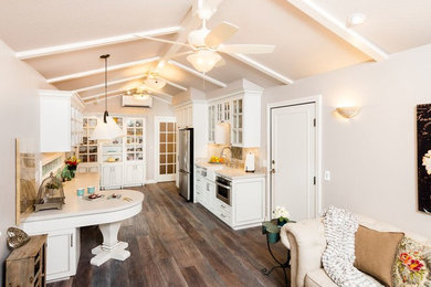 Open concept kitchen - small shabby-chic style galley dark wood floor open concept kitchen idea in Sacramento with a farmhouse sink, white cabinets, quartz countertops, white backsplash, porcelain backsplash, stainless steel appliances, no island and beaded inset cabinets