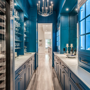 Ispirazione per un'ampia cucina classica con lavello sottopiano, ante in stile shaker, ante blu, top in quarzo composito, paraspruzzi a effetto metallico, paraspruzzi a specchio, elettrodomestici in acciaio inossidabile, parquet chiaro, pavimento beige e top bianco