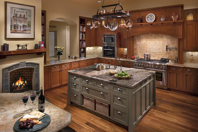 Large transitional l-shaped kitchen photo in Phoenix with recessed-panel cabinets, medium tone wood cabinets, beige backsplash, stainless steel appliances and an island