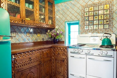 Inspiration for a mid-sized southwestern u-shaped brick floor kitchen remodel in Albuquerque with a double-bowl sink, medium tone wood cabinets, multicolored backsplash, no island, wood countertops, terra-cotta backsplash and colored appliances