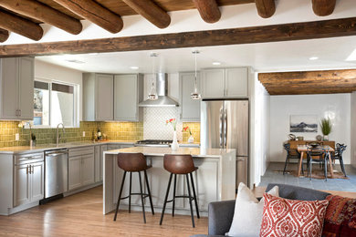 Eat-in kitchen - mid-sized modern l-shaped medium tone wood floor eat-in kitchen idea in Albuquerque with an undermount sink, shaker cabinets, gray cabinets, quartz countertops, green backsplash, glass tile backsplash, stainless steel appliances, an island and white countertops