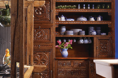 アルバカーキにあるサンタフェスタイルのおしゃれなアイランドキッチン (エプロンフロントシンク、ヴィンテージ仕上げキャビネット) の写真