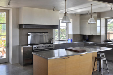Inspiration for a large modern u-shaped kitchen remodel in Albuquerque with flat-panel cabinets, stainless steel cabinets, stainless steel countertops and an island