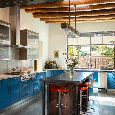 Large eclectic l-shaped dark wood floor and brown floor kitchen photo in Albuquerque with flat-panel cabinets, blue cabinets, stainless steel appliances, an island, white countertops, gray backsplash and cement tile backsplash