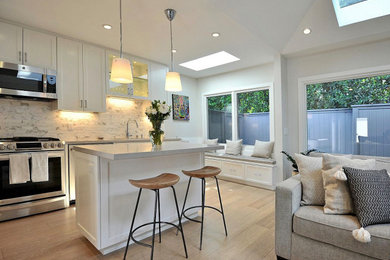 Eat-in kitchen - small coastal u-shaped light wood floor and beige floor eat-in kitchen idea in Los Angeles with an undermount sink, shaker cabinets, white cabinets, quartz countertops, multicolored backsplash, stone tile backsplash, stainless steel appliances, an island and white countertops