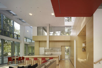 Example of a huge trendy light wood floor kitchen design in Los Angeles with an integrated sink, flat-panel cabinets, light wood cabinets, quartz countertops, metallic backsplash, stainless steel appliances and two islands