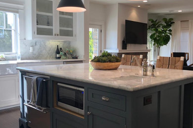 Large farmhouse u-shaped medium tone wood floor and brown floor open concept kitchen photo in Los Angeles with an undermount sink, shaker cabinets, white cabinets, marble countertops, white backsplash, marble backsplash, stainless steel appliances, an island and white countertops