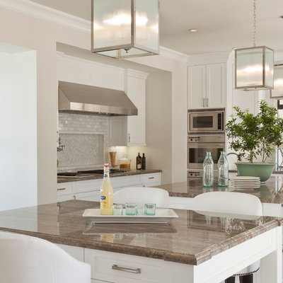 Example of a tuscan eat-in kitchen design in Orange County with white cabinets, gray backsplash, subway tile backsplash and stainless steel appliances