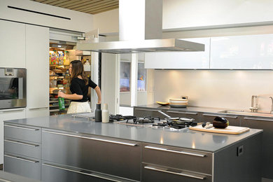 Example of a large trendy ceramic tile eat-in kitchen design in Los Angeles with an undermount sink, flat-panel cabinets, gray cabinets, quartzite countertops, gray backsplash and an island