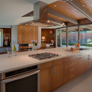 Large midcentury single-wall eat-in kitchen in San Francisco with an undermount sink, flat-panel cabinets, medium wood cabinets, quartz benchtops, vinyl floors, stainless steel appliances, with island and beige floor.