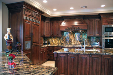 Bild på ett stort vintage kök, med en undermonterad diskho, luckor med upphöjd panel, skåp i mörkt trä, granitbänkskiva, stänkskydd i sten, integrerade vitvaror, travertin golv och en köksö