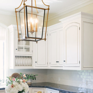 Large rustic open concept kitchen designs - Example of a large mountain style u-shaped terra-cotta tile and brown floor open concept kitchen design in Santa Barbara with an undermount sink, beaded inset cabinets, white cabinets, quartz countertops, white backsplash, subway tile backsplash, stainless steel appliances, an island and black countertops