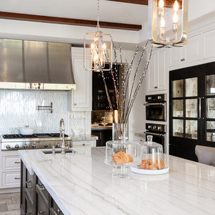 Large transitional kitchen appliance - Inspiration for a large transitional travertine floor and beige floor kitchen remodel in San Diego with an undermount sink, beaded inset cabinets, white cabinets, quartzite countertops, white backsplash, marble backsplash, stainless steel appliances, an island and white countertops