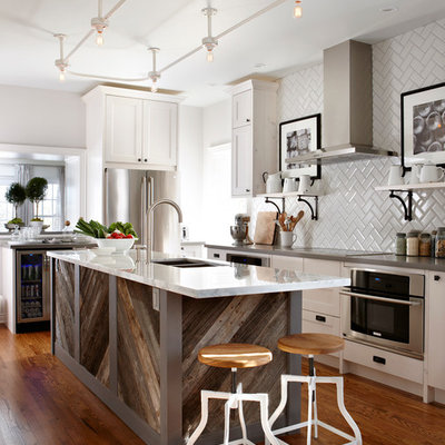 Elegant kitchen photo in Toronto with a double-bowl sink, shaker cabinets, white cabinets, white backsplash, subway tile backsplash and stainless steel appliances
