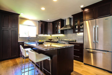 Inspiration for a contemporary l-shaped eat-in kitchen remodel in San Francisco with an undermount sink, flat-panel cabinets, dark wood cabinets, granite countertops, gray backsplash, subway tile backsplash and stainless steel appliances