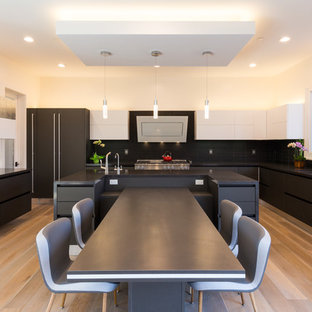 Foto di una grande cucina abitabile minimalista con lavello sottopiano, ante lisce, ante nere, top in quarzo composito, paraspruzzi nero, paraspruzzi con piastrelle in ceramica, elettrodomestici in acciaio inossidabile, isola, top nero, parquet chiaro e pavimento beige