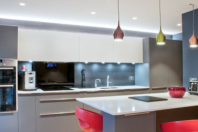 Пример оригинального дизайна: кухня-гостиная среднего размера в стиле модернизм с плоскими фасадами, серыми фасадами, столешницей из кварцита и островом