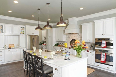 Large elegant l-shaped dark wood floor and tray ceiling kitchen photo in Philadelphia with a farmhouse sink, raised-panel cabinets, white cabinets, quartz countertops, multicolored backsplash, ceramic backsplash, stainless steel appliances, an island and white countertops