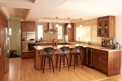 Large arts and crafts u-shaped light wood floor eat-in kitchen photo in Calgary with a single-bowl sink, medium tone wood cabinets, beige backsplash, stainless steel appliances and a peninsula