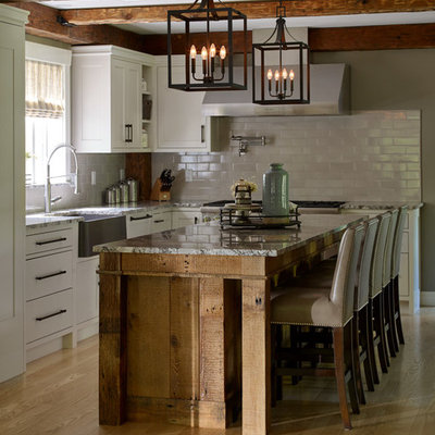 Large cottage light wood floor and beige floor eat-in kitchen photo in Portland Maine with a farmhouse sink, shaker cabinets, white cabinets, granite countertops, gray backsplash, subway tile backsplash, paneled appliances, an island and multicolored countertops