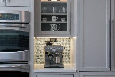 Inspiration for a large traditional l-shaped kitchen/diner in New York with a submerged sink, recessed-panel cabinets, grey cabinets, engineered stone countertops, blue splashback, mosaic tiled splashback, stainless steel appliances, dark hardwood flooring, an island, brown floors and multicoloured worktops.