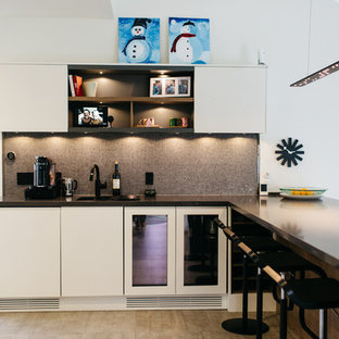 Inspiration for a mid-sized modern u-shaped open plan kitchen in Salt Lake City with flat-panel cabinets, white cabinets, zinc benchtops, black appliances, ceramic floors, with island, a double-bowl sink, brown splashback and mosaic tile splashback.