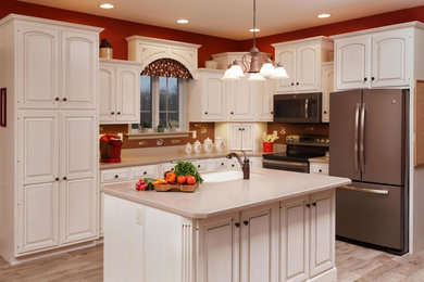 Enclosed kitchen - mid-sized cottage l-shaped medium tone wood floor and brown floor enclosed kitchen idea in Other with an undermount sink, raised-panel cabinets, white cabinets, brown backsplash, stainless steel appliances, an island, granite countertops and brown countertops