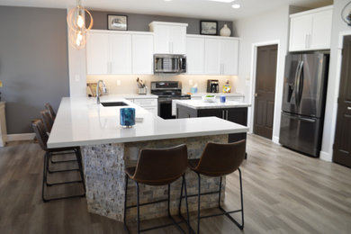 Inspiration for an u-shaped open concept kitchen remodel in Phoenix with an undermount sink, shaker cabinets, white cabinets, stainless steel appliances and an island