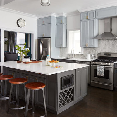 Inspiration for a mid-sized transitional l-shaped dark wood floor and brown floor open concept kitchen remodel in Chicago with an undermount sink, raised-panel cabinets, gray cabinets, metallic backsplash, stainless steel appliances, an island, quartz countertops and mirror backsplash