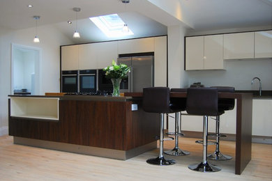 マンチェスターにある広いコンテンポラリースタイルのおしゃれなキッチン (フラットパネル扉のキャビネット、濃色木目調キャビネット、珪岩カウンター) の写真