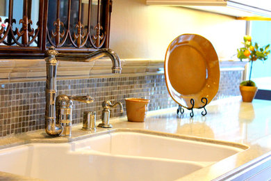 Immagine di una cucina design con lavello a doppia vasca, ante bianche, top in superficie solida, paraspruzzi grigio e paraspruzzi con piastrelle di vetro