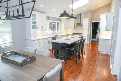 Inspiration for a large transitional u-shaped medium tone wood floor and brown floor eat-in kitchen remodel in Newark with an undermount sink, shaker cabinets, white cabinets, quartzite countertops, multicolored backsplash, stainless steel appliances, an island, multicolored countertops and mosaic tile backsplash