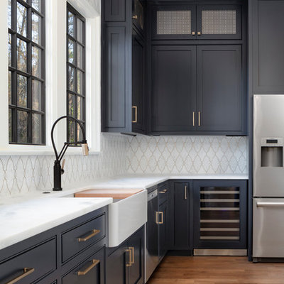 Kitchen - mid-sized traditional l-shaped medium tone wood floor and brown floor kitchen idea in Charlotte with a farmhouse sink, blue cabinets, marble countertops, white backsplash, mosaic tile backsplash, stainless steel appliances and white countertops