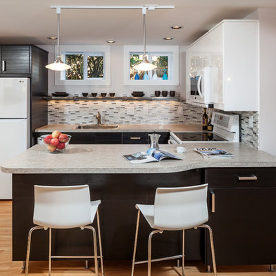 Inspiration for a mid-sized contemporary u-shaped light wood floor and beige floor eat-in kitchen remodel in Portland with a single-bowl sink, flat-panel cabinets, dark wood cabinets, solid surface countertops, multicolored backsplash, glass tile backsplash, white appliances and a peninsula